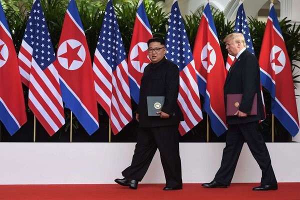 US President Donald Trump (right) walks out with North Korea's leader Kim Jong Un (L) after taking part in a signing ceremony at the end of their historic US-North Korea summit, at the Capella Hotel on Sentosa island in Singapore on June 12, 2018. PHOTO | POOL | ANTHONY WALLACE | AFP